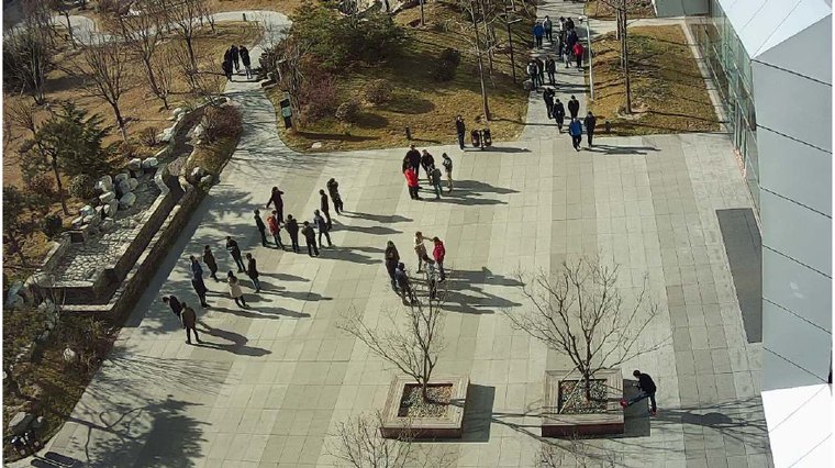 Public plaza with groups of people standing and walking